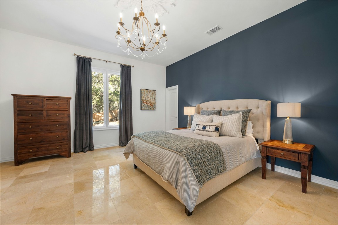 4710 Eck Lane Austin, TX 78734 - Photo 22 of 40 a bedroom with a bed and a chandelier