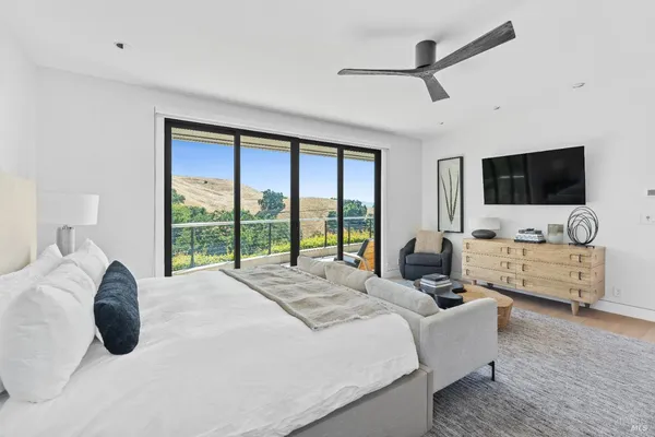 a large bedroom with a bed and a flat screen tv