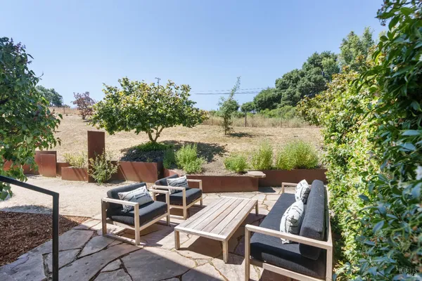 a view of a patio with table and chairs and potted plants