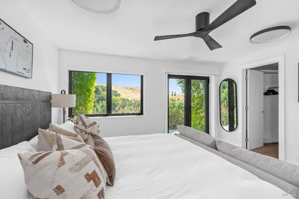 a bedroom with a bed mirror and window
