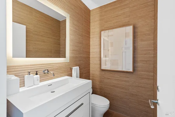 a bathroom with a toilet sink vanity and mirror