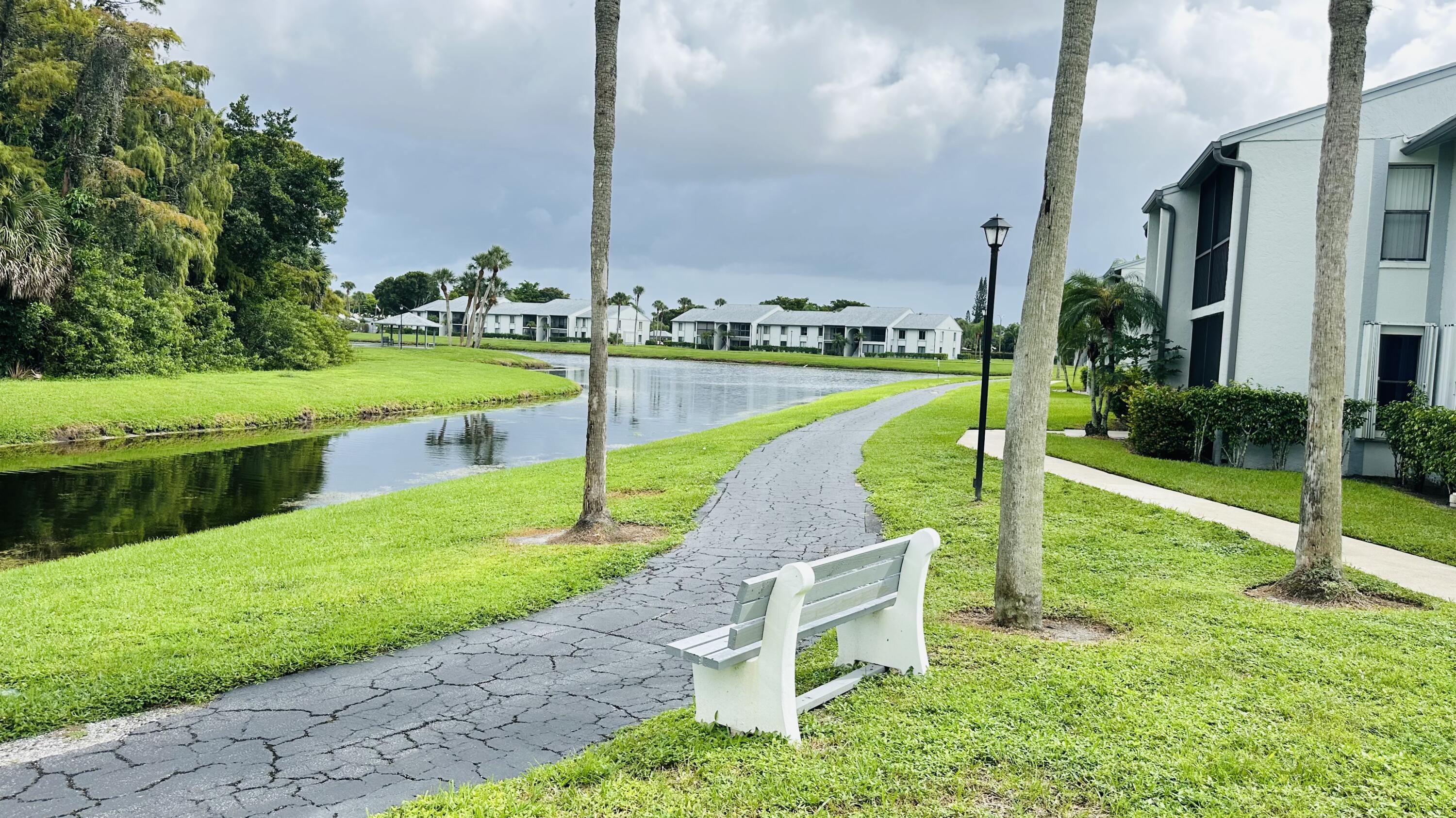 1006 Green Pine Boulevard, Unit H2 West Palm Beach, FL 33409 - Photo 11 of 12 a view of a garden with swimming pool