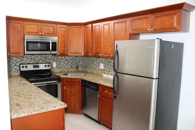 a white refrigerator freezer and a stove sitting inside of a kitchen
