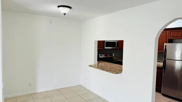 a hallway with cabinets and a refrigerator