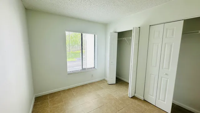 a view of an empty room with window and closet area