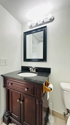 a bathroom with a sink a toilet and mirror