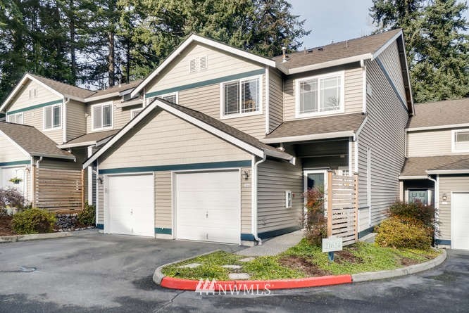 21624 9th Avenue Southeast, Unit D104 Bothell, WA 98021 - Photo 1 of 16 a view of a white house with large windows and a small yard