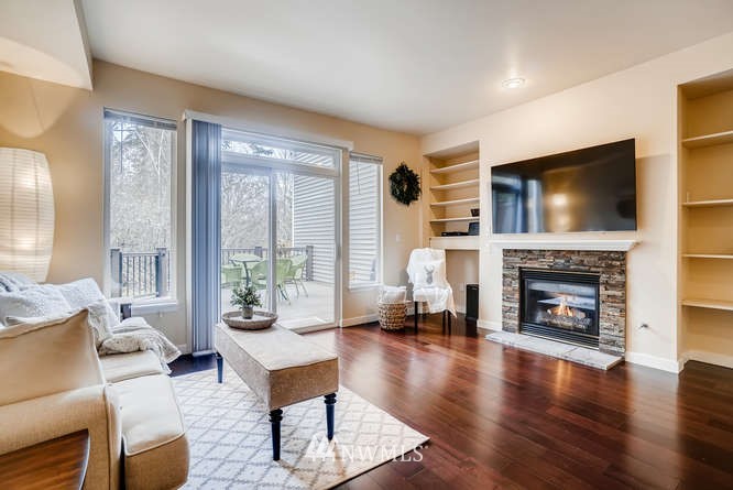 21624 9th Avenue Southeast, Unit D104 Bothell, WA 98021 - Photo 4 of 16 a living room with furniture a fireplace a flat screen tv and a large window