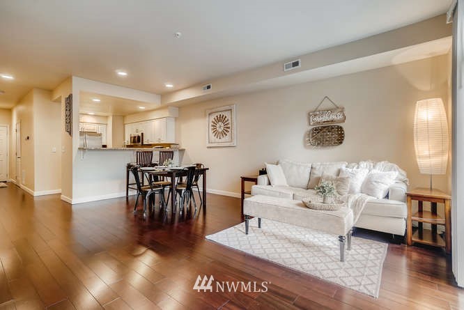 21624 9th Avenue Southeast, Unit D104 Bothell, WA 98021 - Photo 5 of 16 a living room with furniture and a dining table with wooden floor