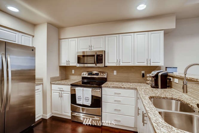 21624 9th Avenue Southeast, Unit D104 Bothell, WA 98021 - Photo 7 of 16 a kitchen with granite countertop a sink stainless steel appliances and cabinets