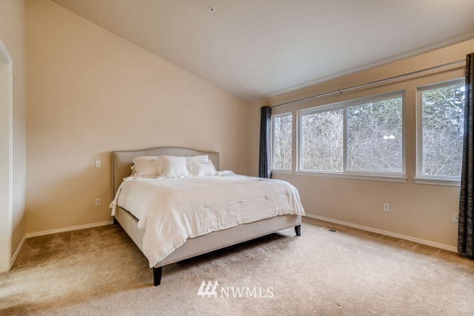21624 9th Avenue Southeast, Unit D104 Bothell, WA 98021 - Photo 9 of 16 a large bed sitting in a bedroom next to a window