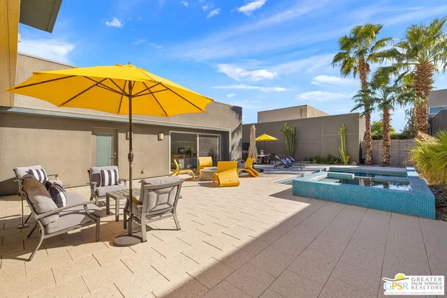 a view of a patio with dining table and chairs under an umbrella