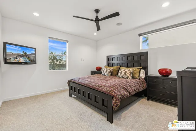 a spacious bedroom with a bed and a chandelier