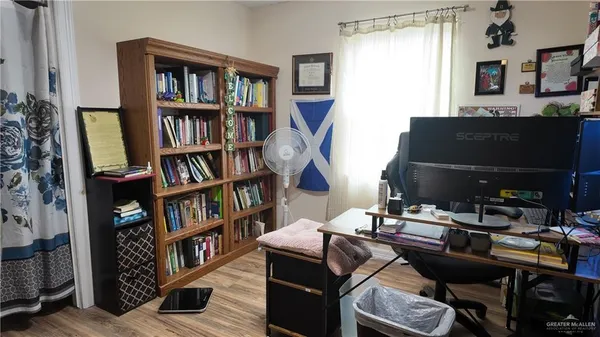 a view of a workspace with bookshelf and a window