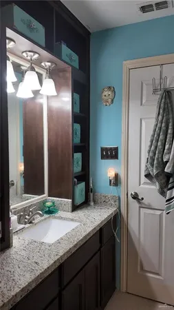 a bathroom with a granite countertop sink and a mirror