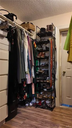 a view of walk in closet with clothes and shoes