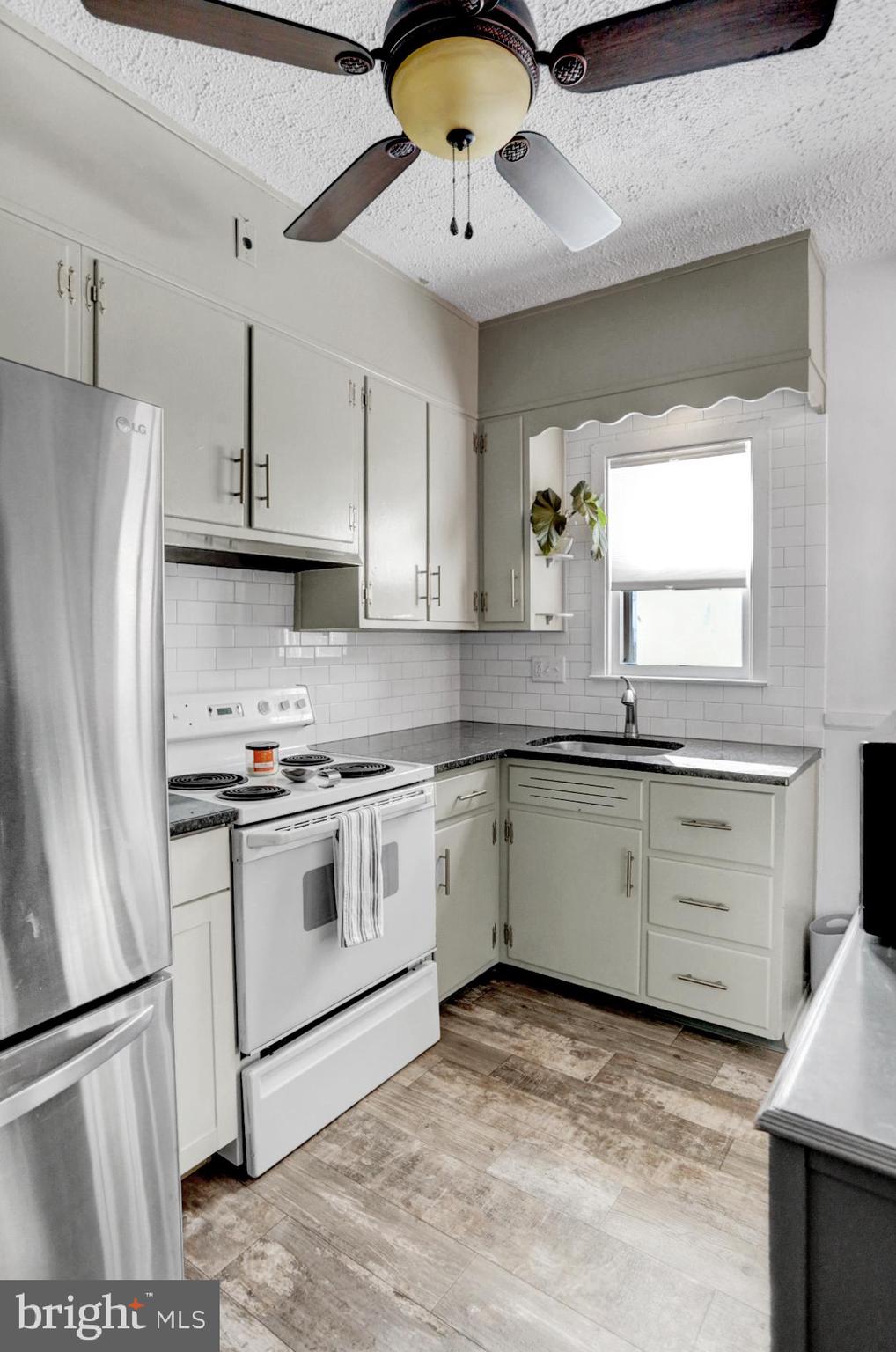 230 South 18th Street Reading, PA 19602 - Photo 11 of 24 a kitchen with stainless steel appliances granite countertop a sink a stove a refrigerator and island