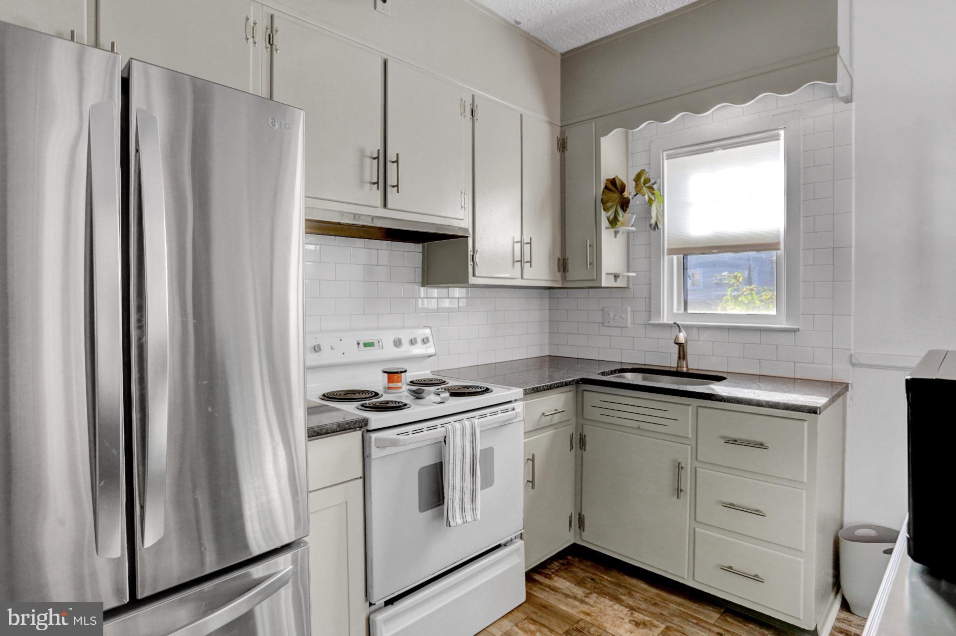230 South 18th Street Reading, PA 19602 - Photo 10 of 24 a kitchen with white cabinets and white appliances