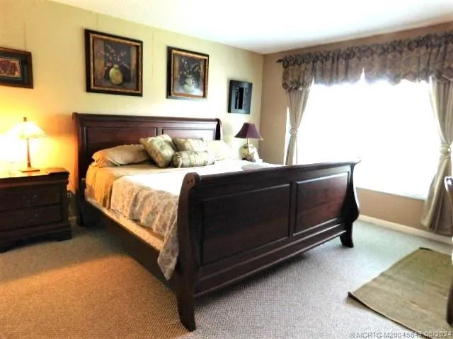 a bedroom with a bed lamp and a window