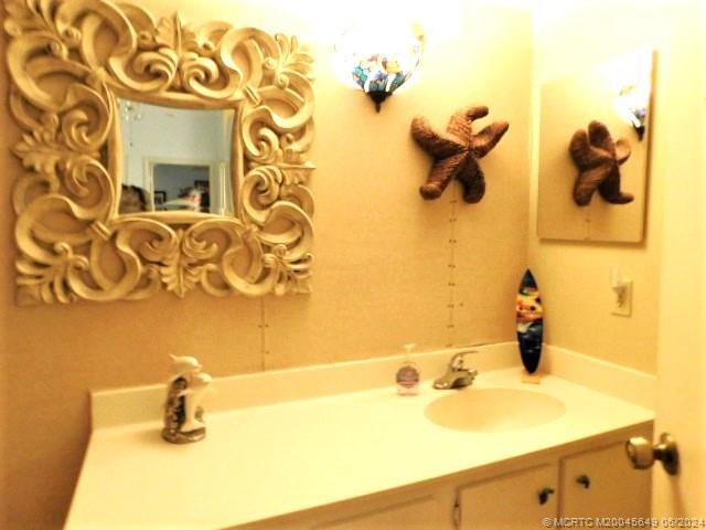 2273 Northwest 22nd Avenue, Unit 104 Stuart, FL 34994 - Photo 16 of 17 a bathroom with a sink and mirror