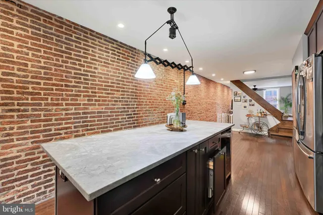a kitchen with a sink a counter space wooden floor and staircase