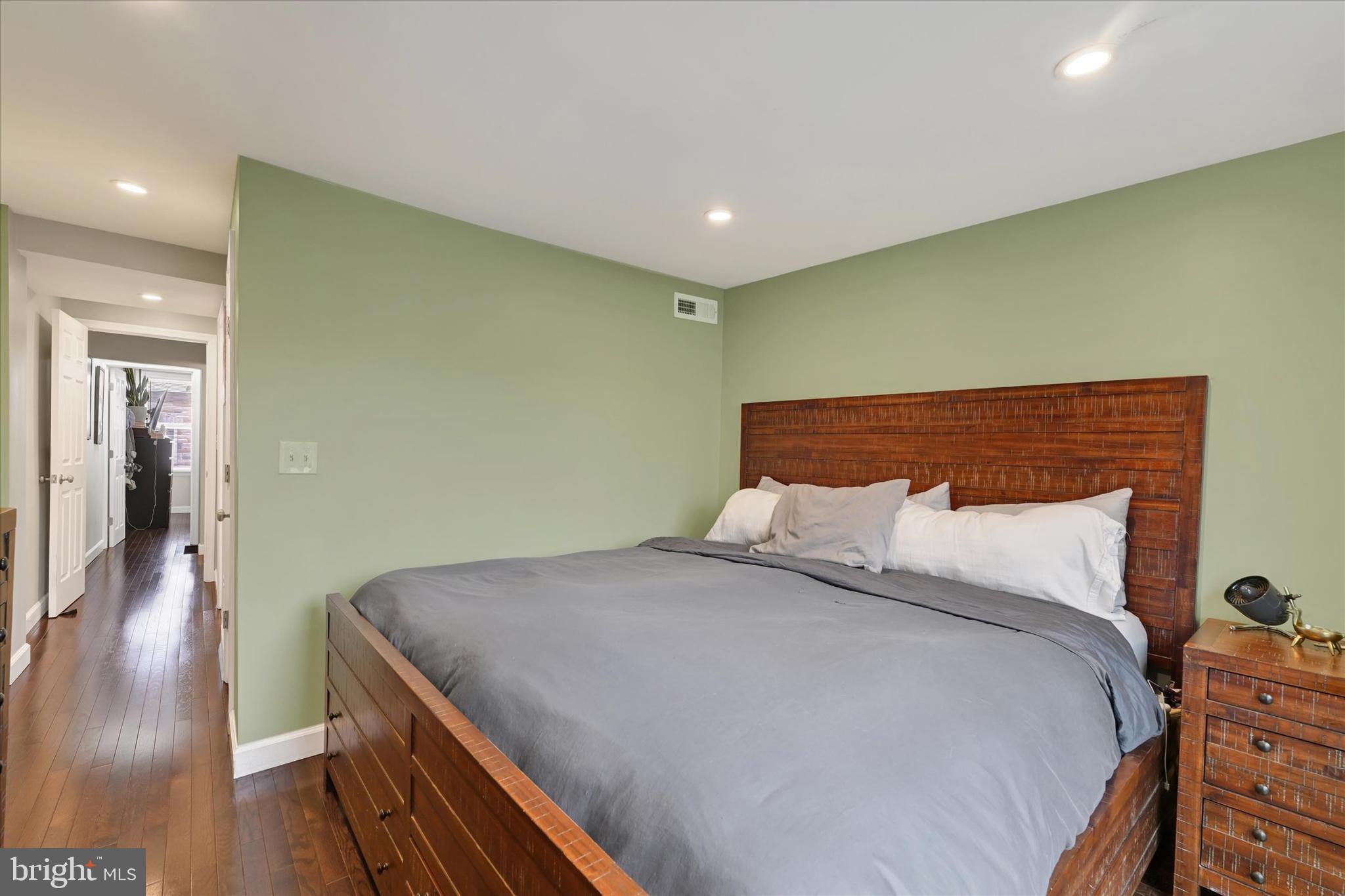 1436 Andre Street Baltimore, MD 21230 - Photo 20 of 35 a bed sitting in a room next to a lamp with wooden floor