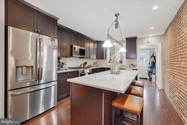 a kitchen with stainless steel appliances a refrigerator sink and stove