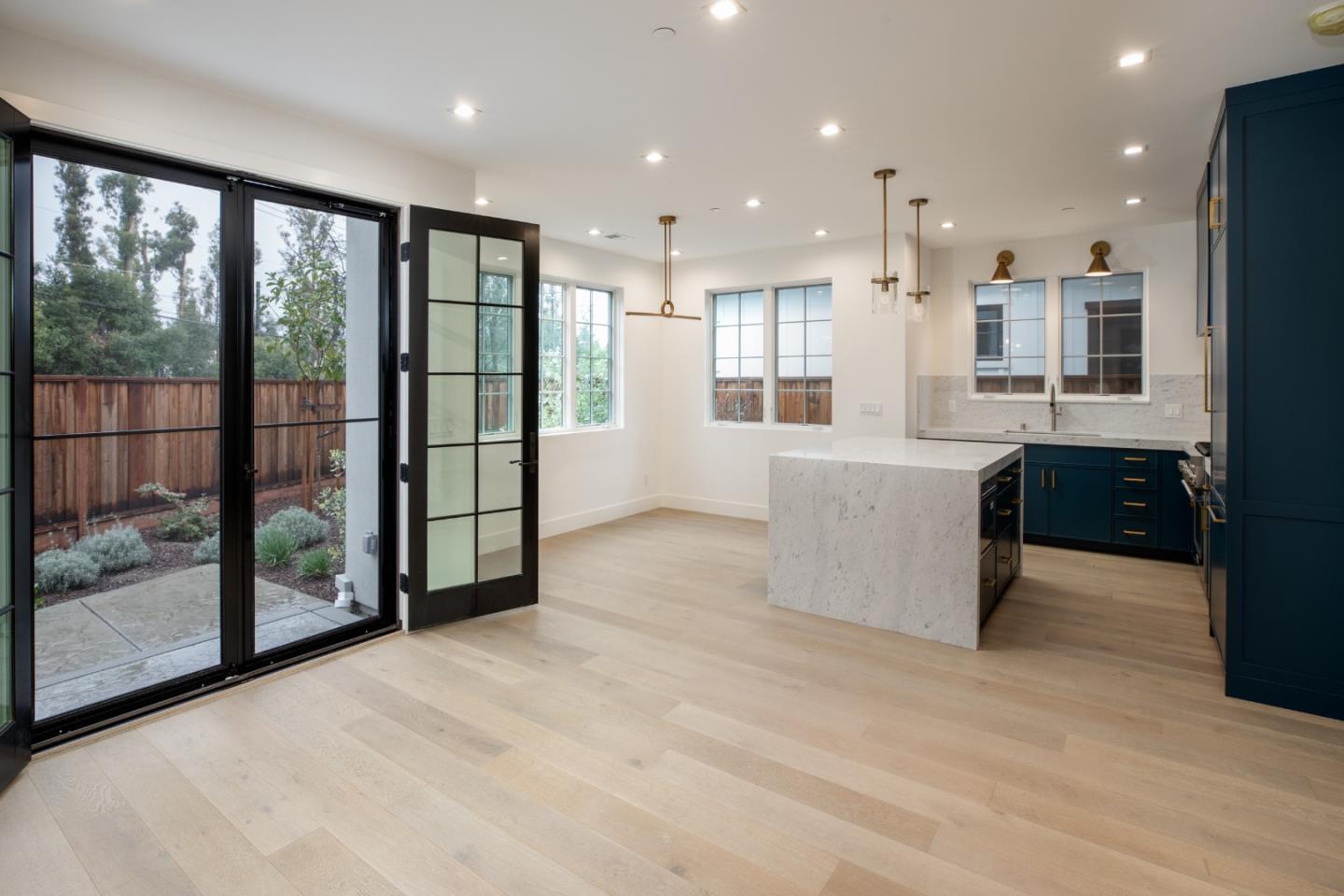 737 Linden Avenue Burlingame, CA 94010 - Photo 27 of 42 a view of an empty room with a kitchen view and large windows