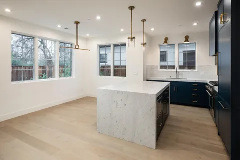 a kitchen with a stove a sink a center island and a window