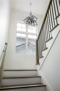 a view of staircase with wooden floor and white walls