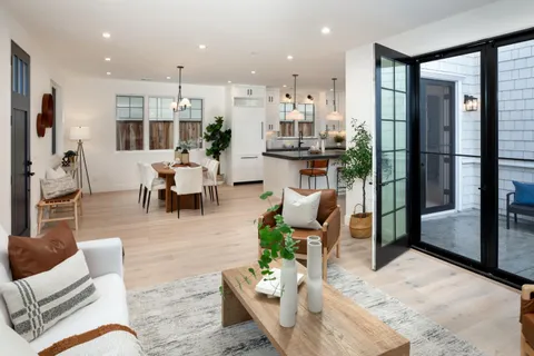 a living room with furniture wooden floor and a large window