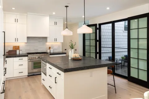 a kitchen with stainless steel appliances granite countertop a stove a sink a center island and a refrigerator