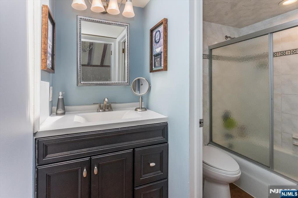 699 Kent Avenue Teaneck, NJ 07666 - Photo 18 of 31 a bathroom with a sink a toilet and a mirror