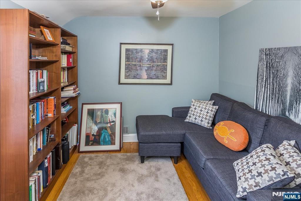699 Kent Avenue Teaneck, NJ 07666 - Photo 19 of 31 a living room with lounge chair and a book shelf