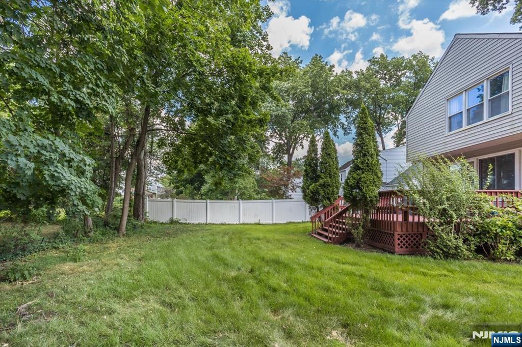 699 Kent Avenue Teaneck, NJ 07666 - Photo 24 of 31 a view of a backyard with potted plants and large trees