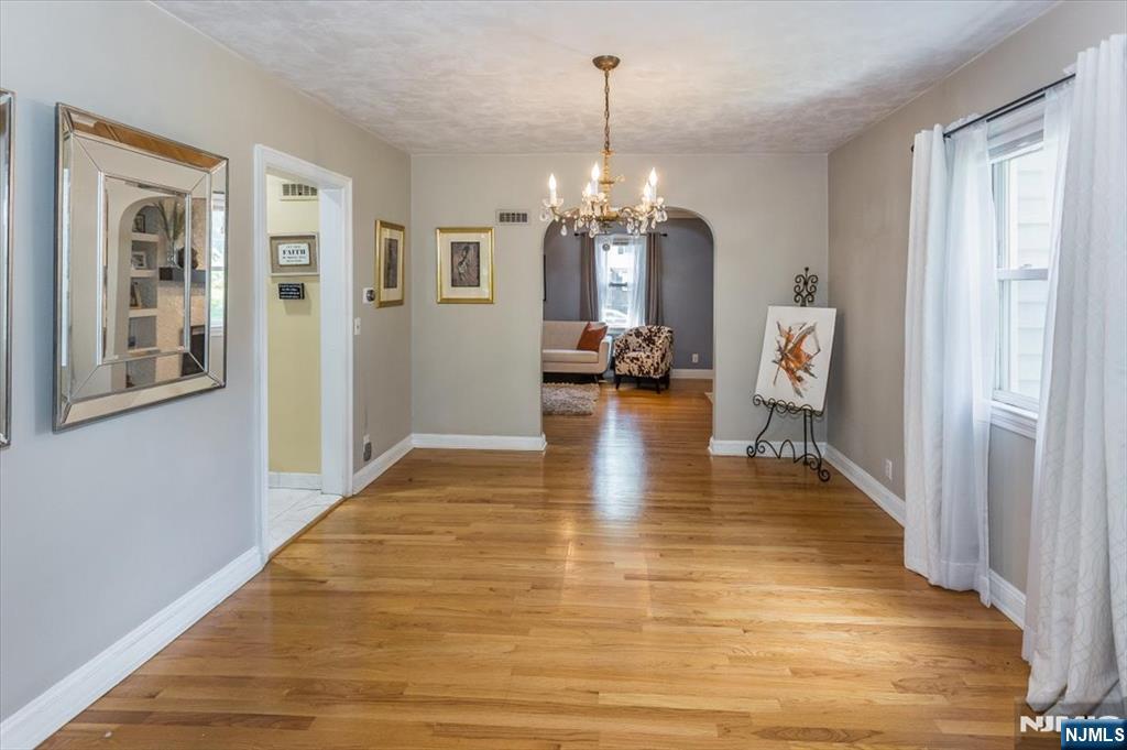699 Kent Avenue Teaneck, NJ 07666 - Photo 9 of 31 a view of a livingroom with furniture wooden floor a chandelier