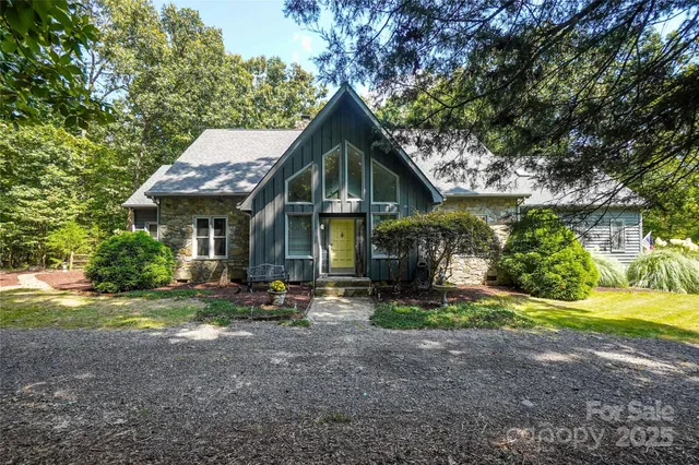 a front view of a house with a yard and trees