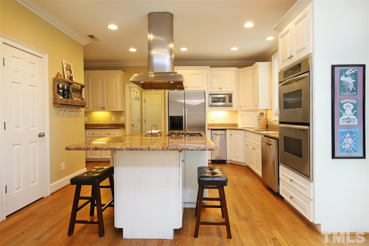 7012 Wildlife Trail Raleigh, NC 27613 - Photo 22 of 30 a kitchen with stainless steel appliances kitchen island granite countertop a stove and a refrigerator