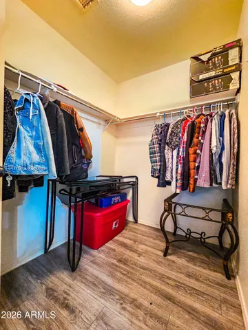 a view of walk in closet with clothes and shoes