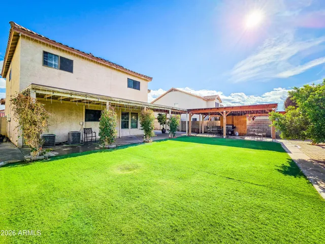 a patio with a table and chairs and couches with wooden floor