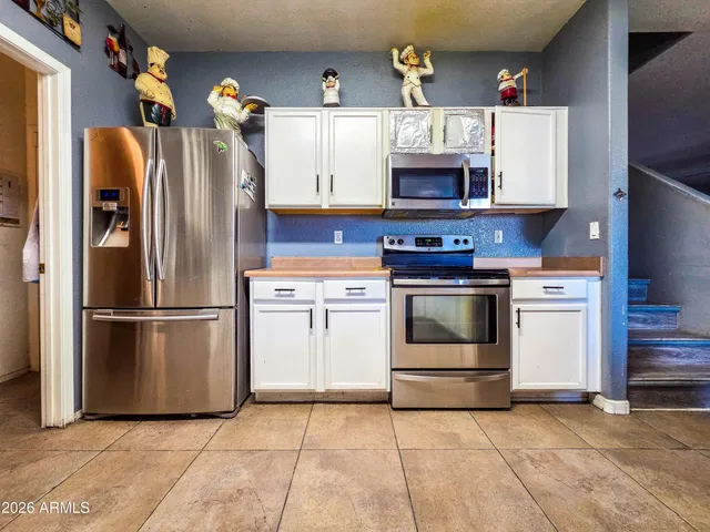 a kitchen with stainless steel appliances granite countertop a stove top oven and refrigerator