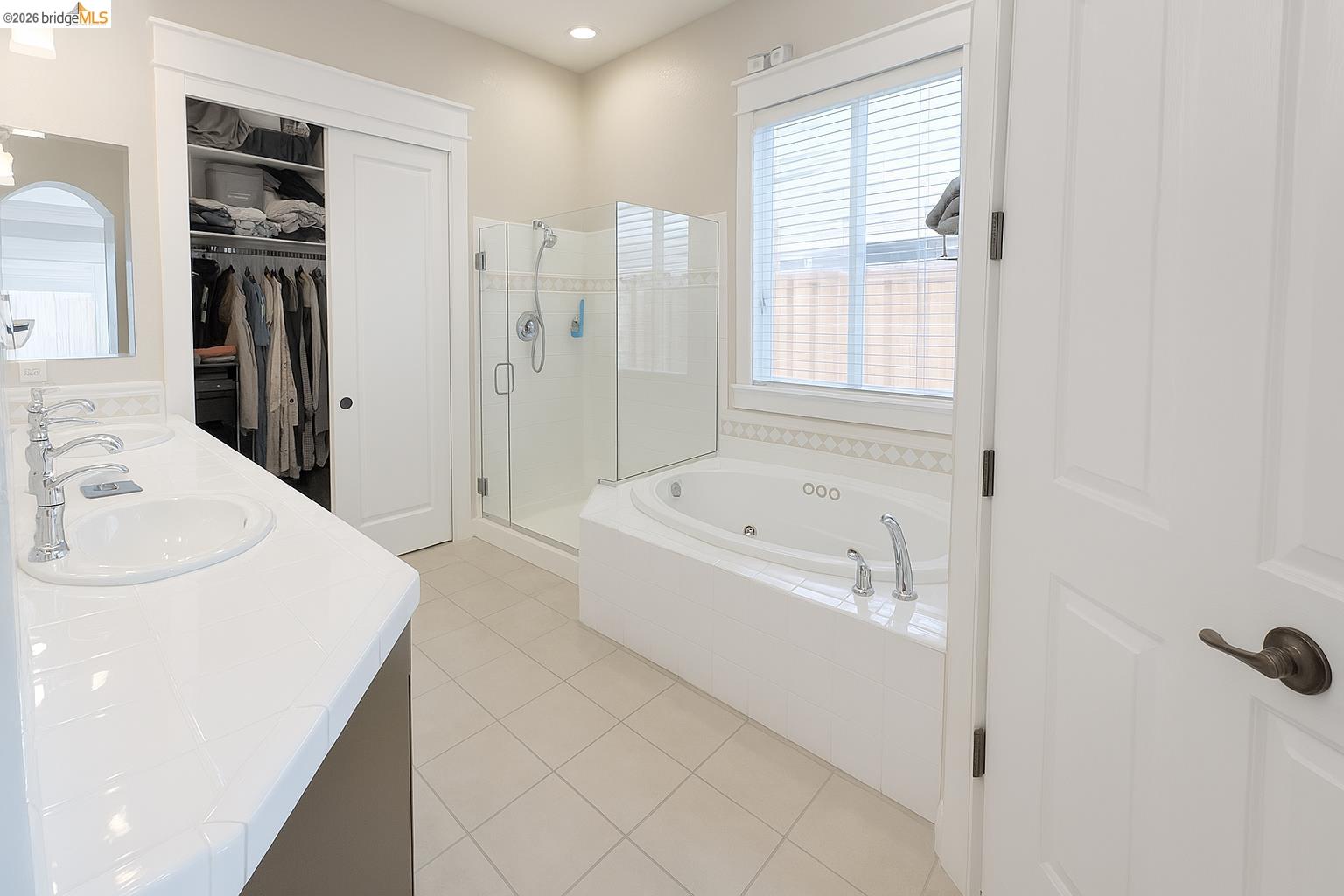 2072 Bridgeport Loop Discovery Bay, CA 94505 - Photo 13 of 26 Bathroom with a shower stall, a whirlpool tub, a spacious closet, light tile patterned flooring, and double vanity