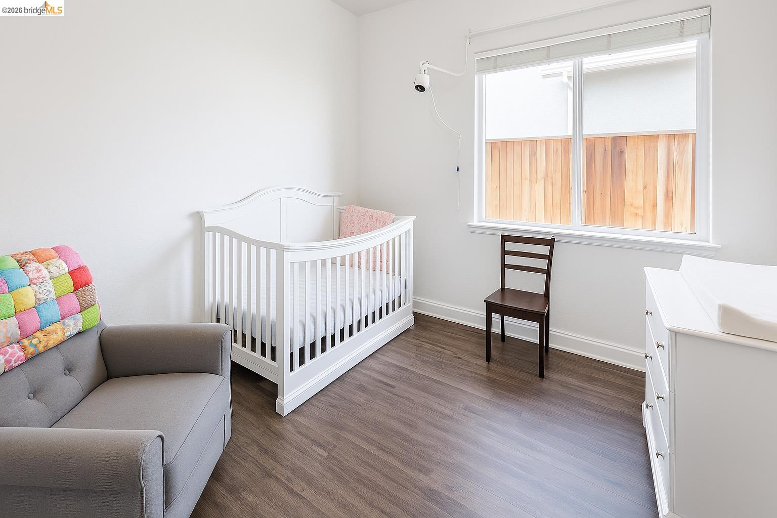 2072 Bridgeport Loop Discovery Bay, CA 94505 - Photo 14 of 26 Bedroom with dark wood finished floors and a crib