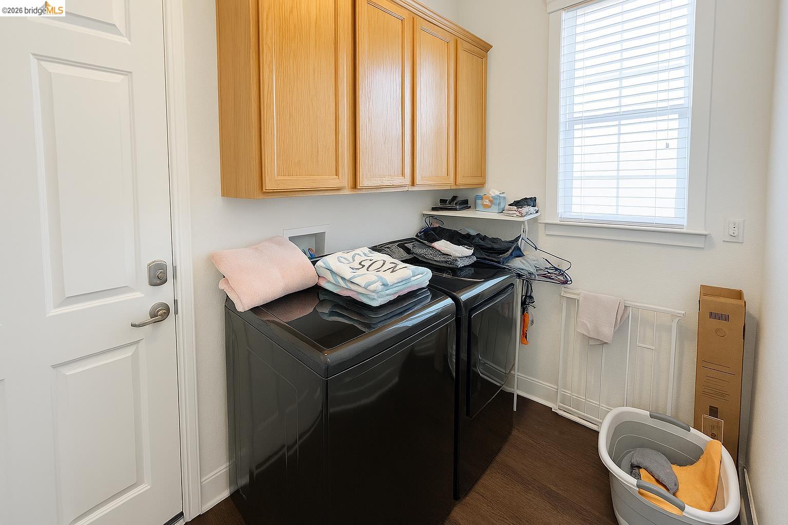 2072 Bridgeport Loop Discovery Bay, CA 94505 - Photo 19 of 26 Washroom featuring dark wood-style flooring, washer and clothes dryer, and cabinet space