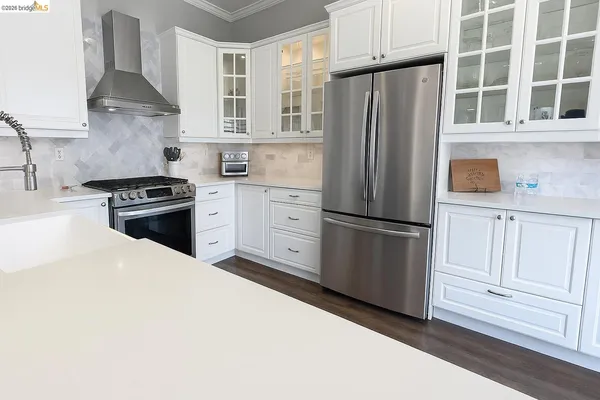 a kitchen with stainless steel appliances granite countertop a refrigerator stove and sink