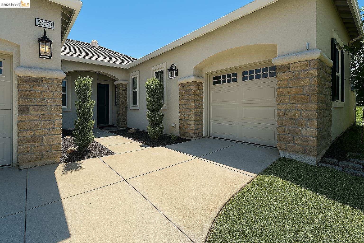 2072 Bridgeport Loop Discovery Bay, CA 94505 - Photo 2 of 26 View of property exterior with stone siding, stucco siding, driveway, and a garage