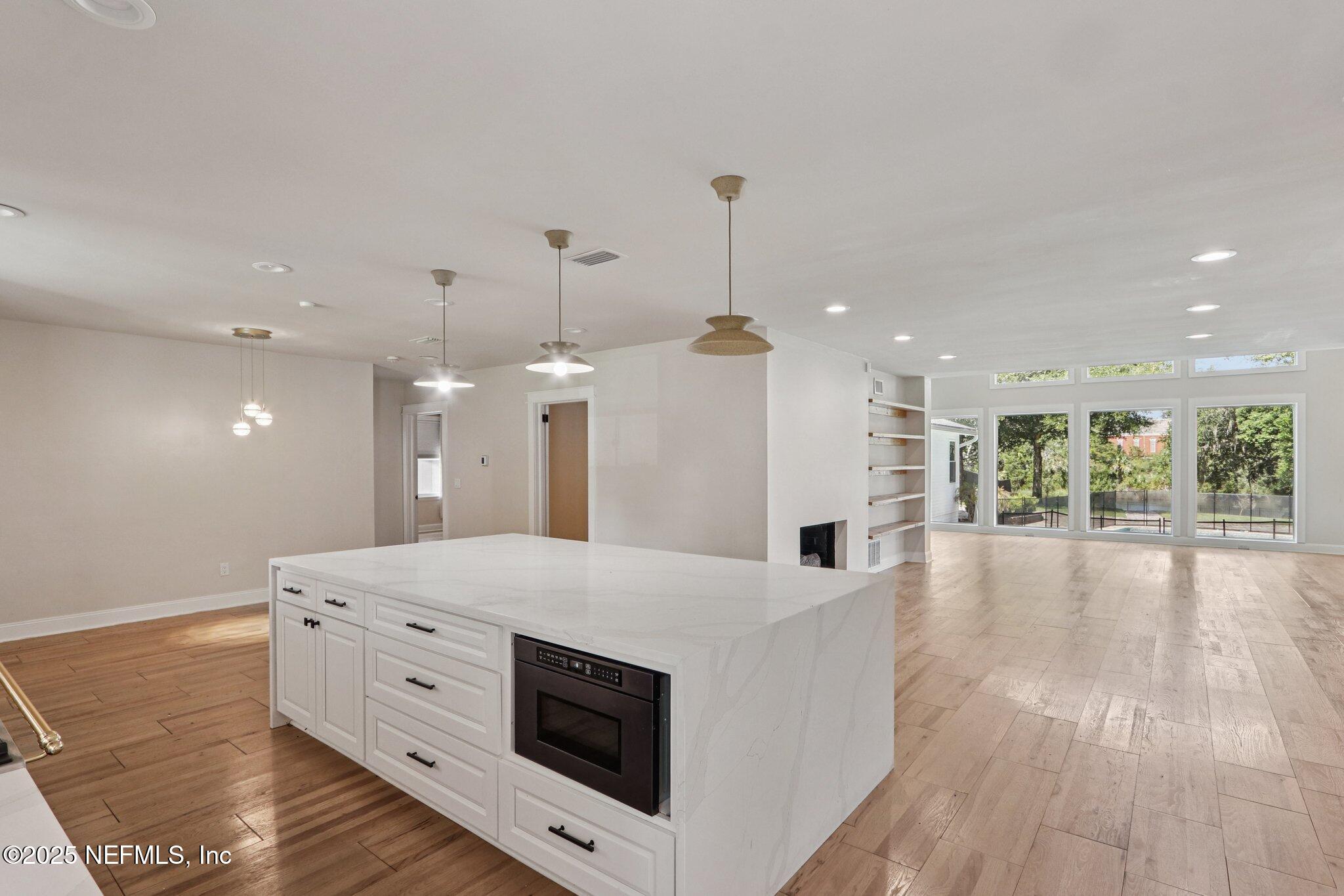 1536 Mayfair Road Jacksonville, FL 32207 - Photo 21 of 58 a large white kitchen with granite countertop a stove and a wooden floor