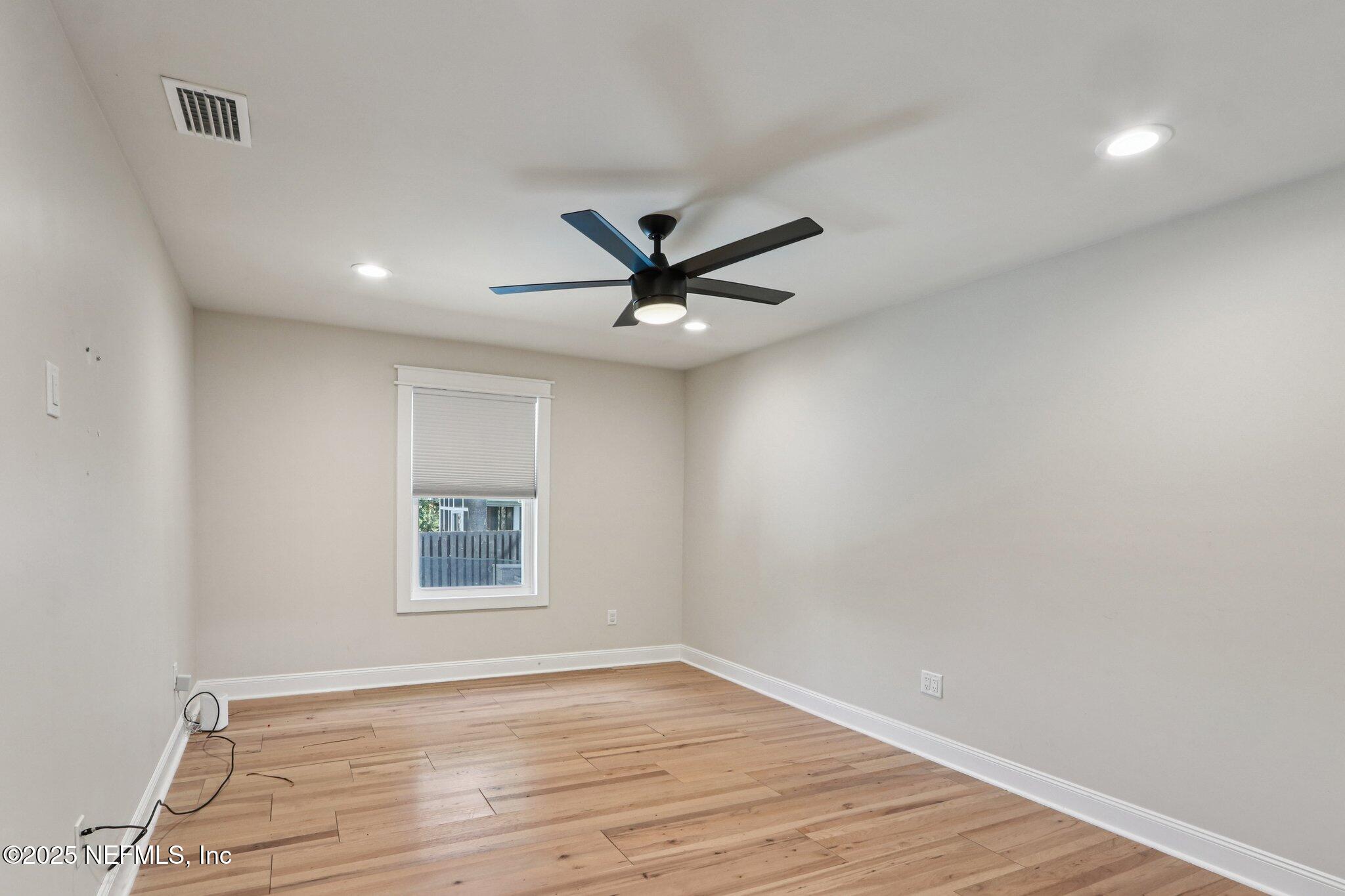 1536 Mayfair Road Jacksonville, FL 32207 - Photo 37 of 58 an empty room with wooden floor and ceiling fan