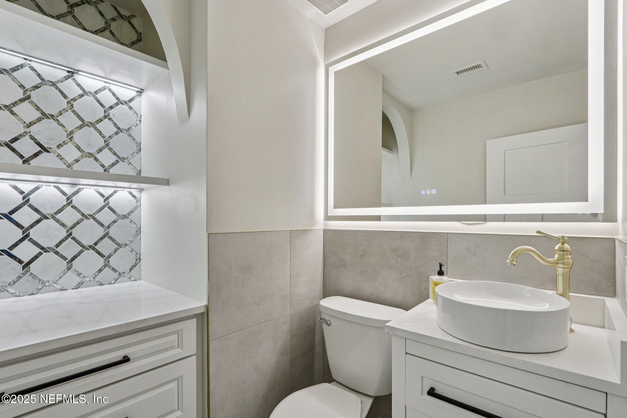 1536 Mayfair Road Jacksonville, FL 32207 - Photo 39 of 58 a bathroom with a sink a toilet and a mirror