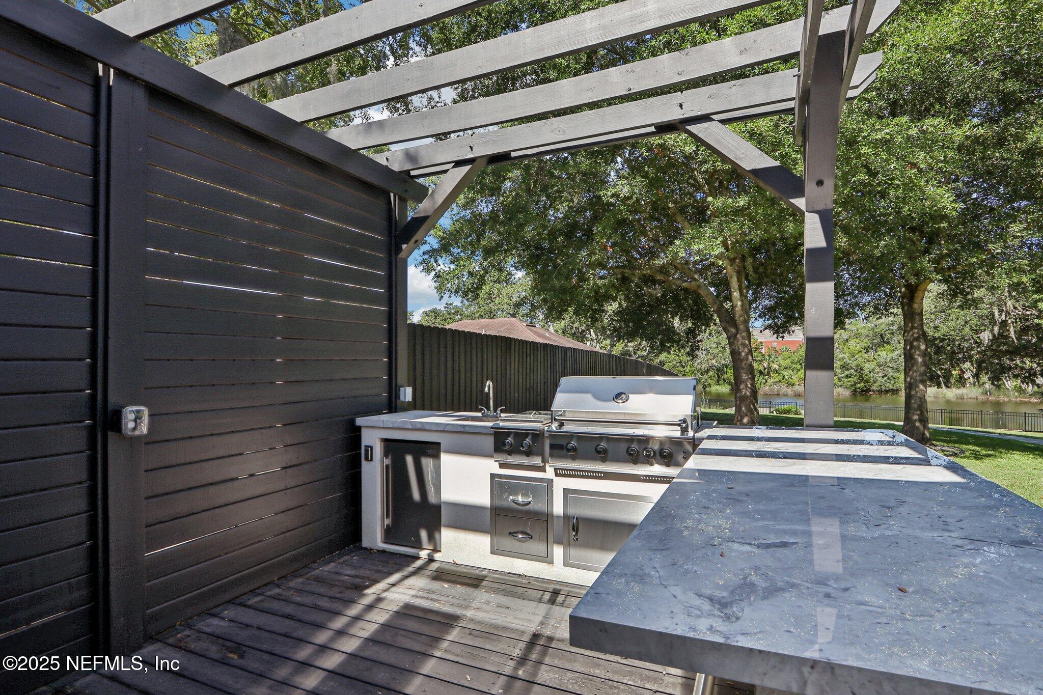 1536 Mayfair Road Jacksonville, FL 32207 - Photo 45 of 58 a view of a patio with table and chairs with wooden floor and fence